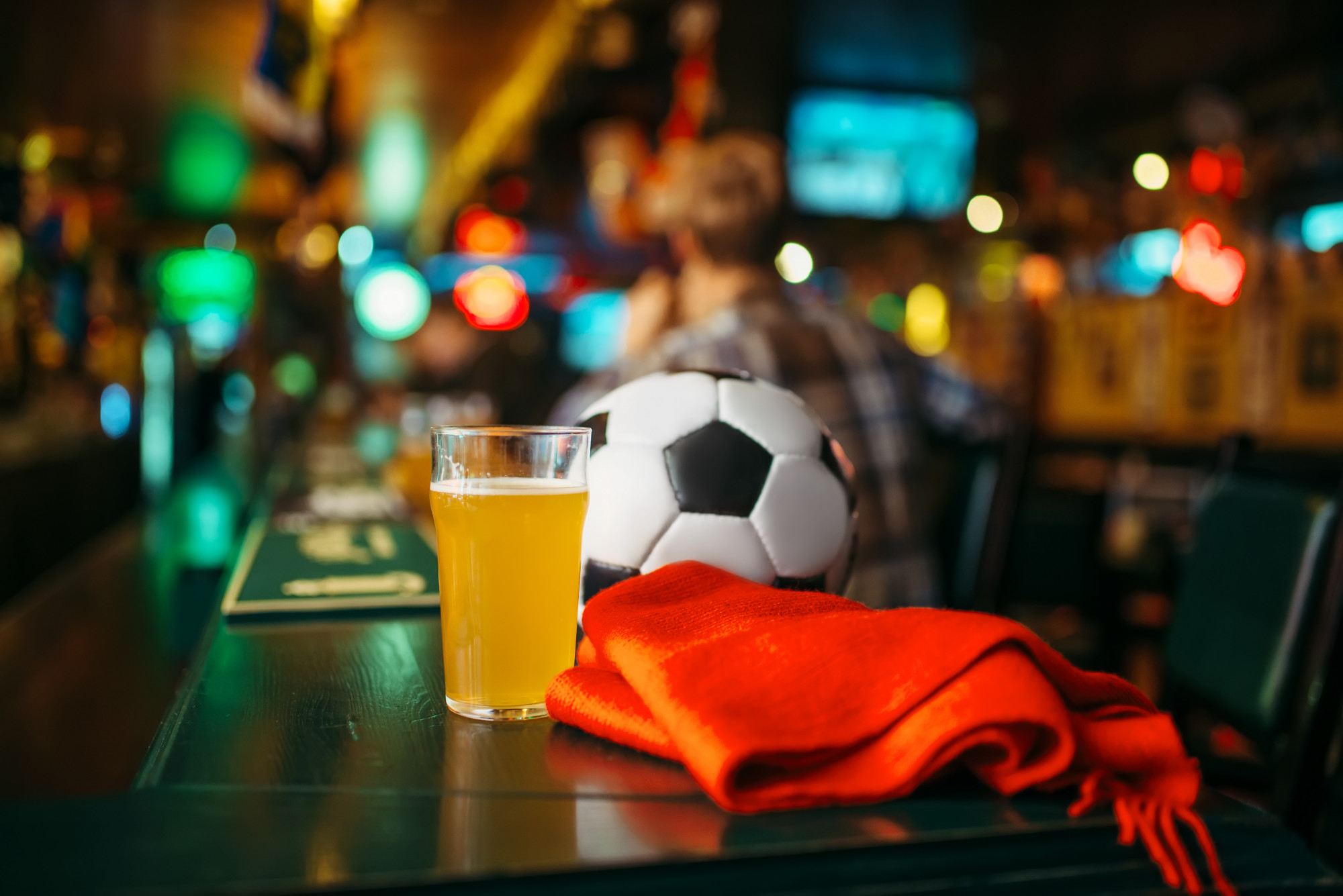 Balle, bière et écharpe rouge sur le comptoir du bar des sports,